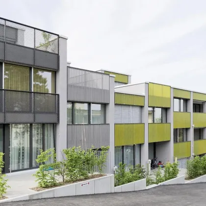Mehrfamilienhaus mit Metallfassade, Balkonen und Fenstern