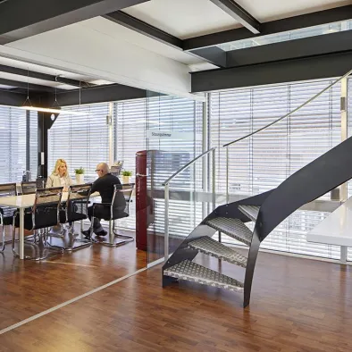 Büroinnenraum mit Stahltreppe und Glasgeländer